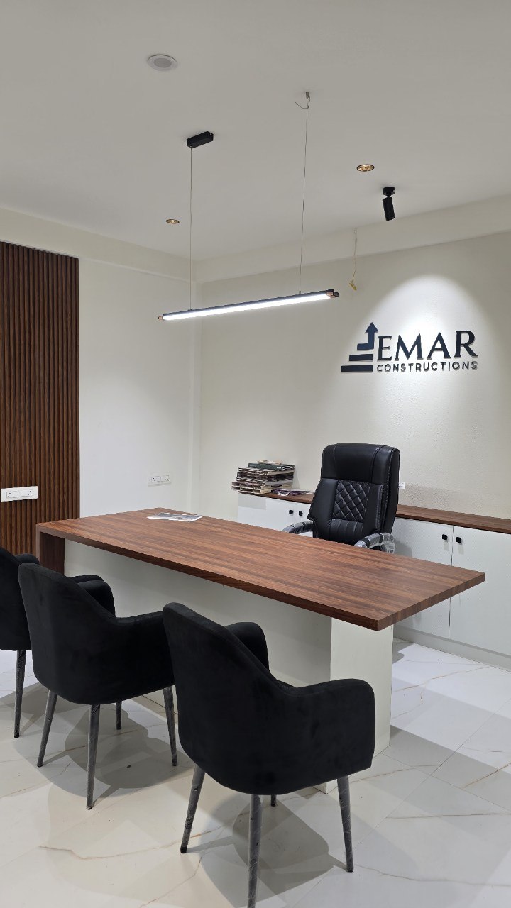 Director's cabin with walnut desk, fluted screen and brand-lit wall